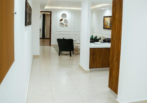 a kitchen and living room with a white tile floor at Goldcrest - 1 Bedroom Luxury Apartment - Lahore in Lahore