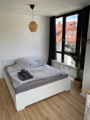 a white bed in a room with a window at Apartment zentral in Gießen mit Balkon! in Gießen