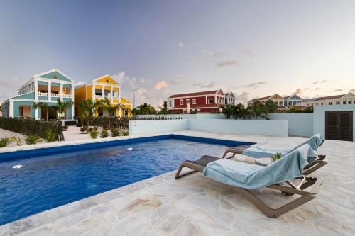 a villa with a swimming pool and a chaise lounge at Casa Blue Marlin (1e verdieping) in Kralendijk