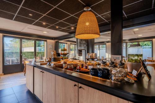 a kitchen with a counter with food on it at Campanile NATURE - Bordeaux Est Artigues in Artigues-près-Bordeaux