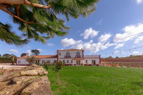 a house with a green lawn in front of it at Quinta da Murnalha in Azueira