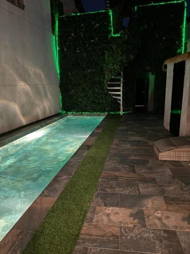 - une piscine avec des lumières vertes la nuit dans l'établissement Villa élégante à Marseille avec grande piscine privée, à Marseille