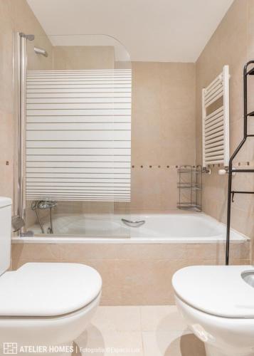 a bathroom with a tub and a toilet and a sink at Las Margas Vistas Golf in Sabiñánigo