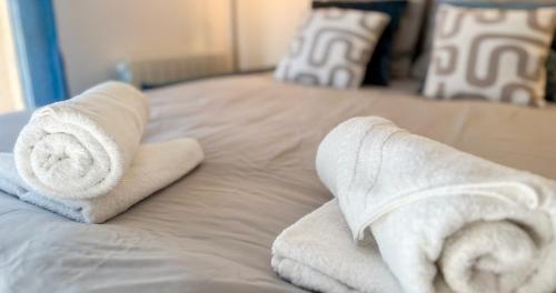 une pile de serviettes posée sur un lit dans l'établissement AC - Private Parking - Balcony - View of the Remparts!, à Avignon
