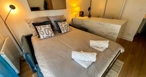 - un lit blanc avec des oreillers dans l'établissement AC - Private Parking - Balcony - View of the Remparts!, à Avignon