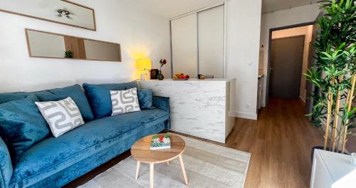 un salon avec un canapé bleu et une table dans l'établissement AC - Private Parking - Balcony - View of the Remparts!, à Avignon