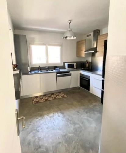 une cuisine avec des armoires blanches et un évier dans l'établissement Spacious house with balcony, à Sainte-Maxime