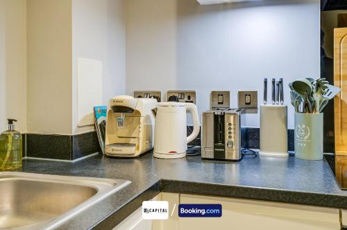 a kitchen counter with many appliances on it at Last-Minute Secure l Sleeps Up to 8 l 2 Bedroom Apt By Capital Retreats Short Lets & Serviced Accommodation London With Balcony, Free WiFi in Colindale