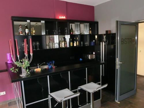 a bar with two stools in a room at Hotel Bismarckhöhe in Tecklenburg