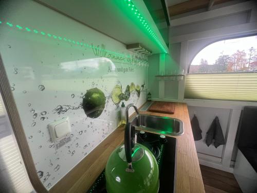 a kitchen with a green sink and a window at Hausboot Rollyboot in Joachimsthal