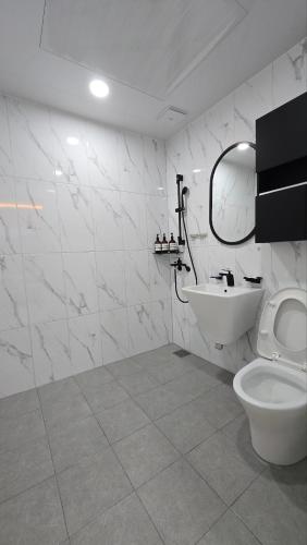 a white bathroom with a toilet and a sink at A Bridge House 5-B in Incheon
