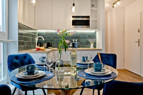 a dining room with a glass table and blue chairs at Casa Baia BlueApart Hel in Hel