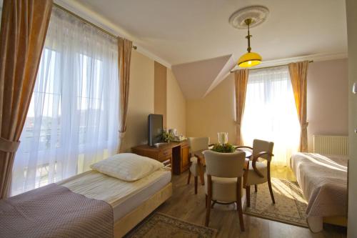 a hotel room with a bed and a table and a room at Villa Tropikana in Łeba