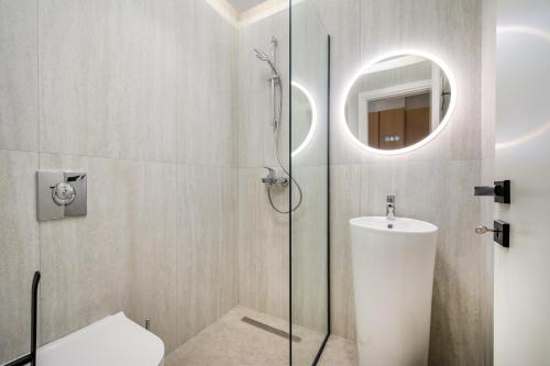 a bathroom with a shower with a toilet and a sink at Beach Luxury Homes - Zoe in Lampi