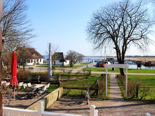a park with benches and a table and an umbrella at Hotel Hiddensee Hitthim in Kloster