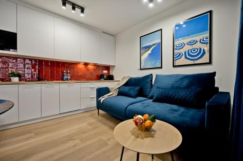 a living room with a blue couch and a table at Casa Baia BlueApart Hel in Hel