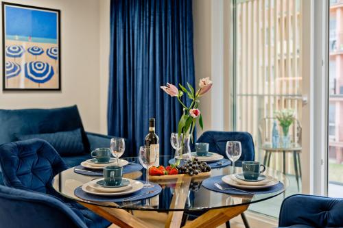 a dining room with a table with plates and wine glasses at Casa Baia BlueApart Hel in Hel