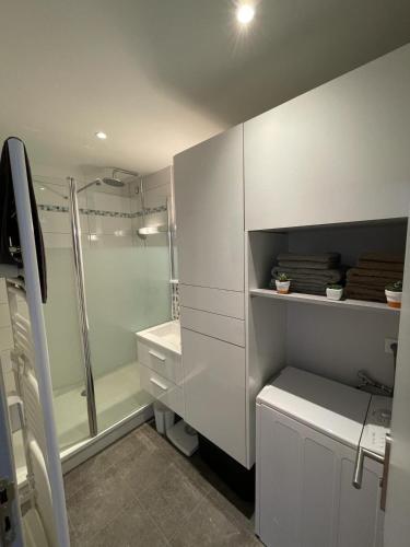 une salle de bain blanche avec douche et toilettes dans l'établissement Au coeur de Chantilly, près de Paris et du Parc Astérix, à Chantilly