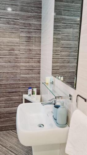 a bathroom with a white sink and a mirror at 2 - BLUE WORLD - Al Dana Villas in Fujairah