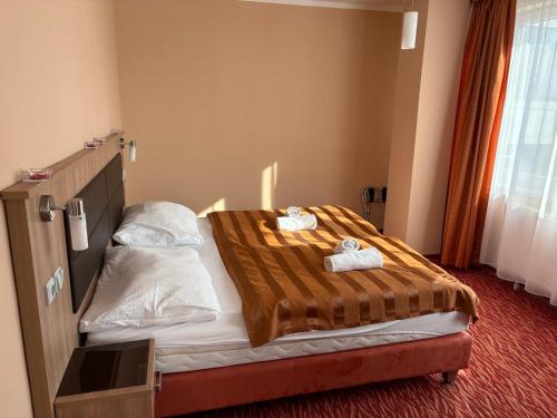 a hotel room with a bed with towels on it at Hotel Opera in Jaroměřice na Rokytné