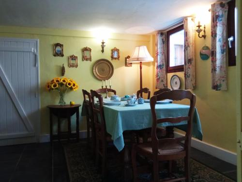 a dining room with a blue table and chairs at Les Terrasses Chambre d'Hôtes in Huelgoat