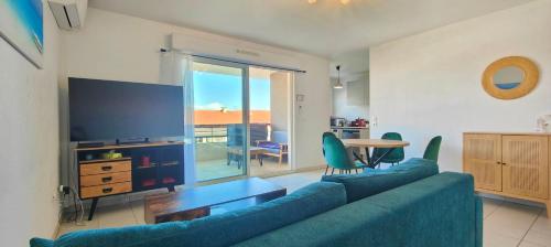 un salon avec un canapé bleu et une télévision dans l'établissement Flat in Fréjus with balcony air co and parking, à Fréjus