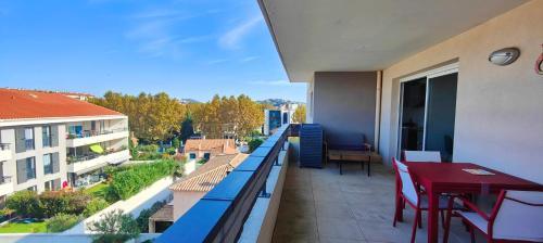 un balcon avec une table et des chaises sur un immeuble dans l'établissement Flat in Fréjus with balcony air co and parking, à Fréjus