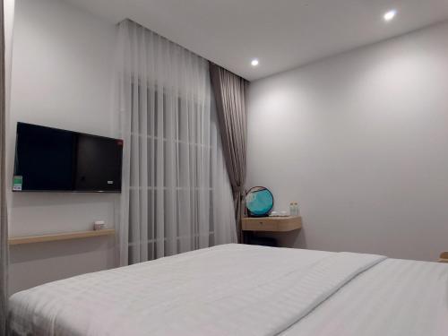 a bedroom with a bed and a flat screen tv at Sun Bay Hotel Phu Quoc in Phu Quoc