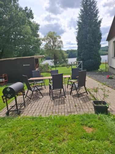 a patio with chairs and a table and a grill at Stará Pošta in Cheb