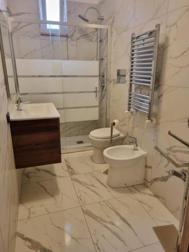 a white bathroom with a toilet and a sink at Appartmenti 3 TORRI in Maddaloni
