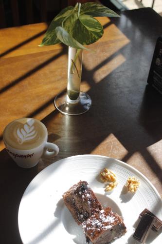 un piatto bianco con un pezzo di torta e una tazza di caffè di Hostal Restaurante Bustos a Villarrubio