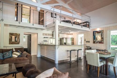 Il comprend un salon avec une mezzanine et une cuisine. dans l'établissement Magnifique villa climatisée -10 personnes avec Piscine et pétanque - Pyla, à La Teste-de-Buch