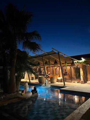 - une piscine avec un pavillon et un palmier dans l'établissement Escale à Bali, à Lançon-Provence