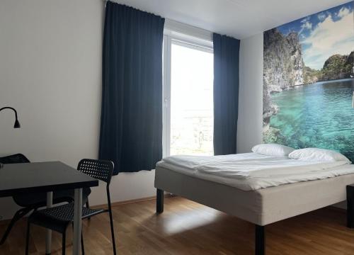 a bedroom with a bed and a desk and a window at P-Hotels Brattøra in Trondheim