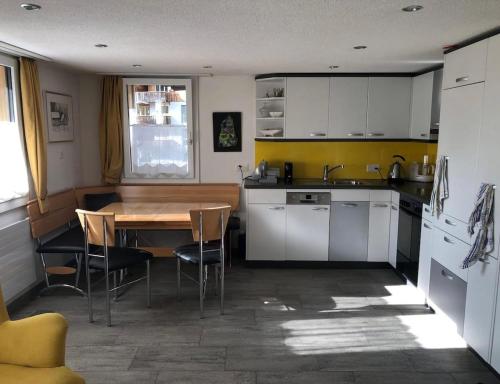 a kitchen with a wooden table and a table and chairs at Ruhig und Zentral in Unterschächen