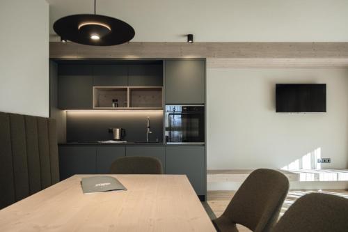 a dining room with a table and a kitchen at Haunold Homes in San Candido