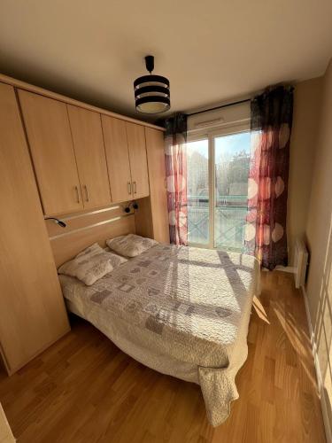 un dormitorio con una cama y una ventana en Appartement proche mer, en Bray-Dunes