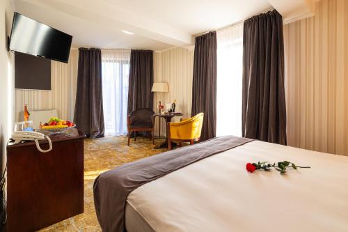 a hotel room with a bed with flowers on it at Hotel Brilliant Plaza in Zalău