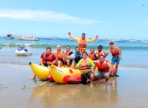 a group of people on the beach with anlatable raft at Casa Entre Rocas y Veleros in Los Órganos