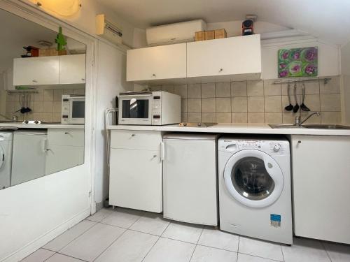 une cuisine avec un lave-linge et un micro-ondes dans l'établissement France, hyper centre - Wifi, AC, 2pers, à Nice