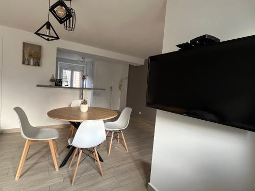 d'une salle à manger avec une table, des chaises et une télévision à écran plat. dans l'établissement Charmant appartement au cœur de Buhl, à Buhl
