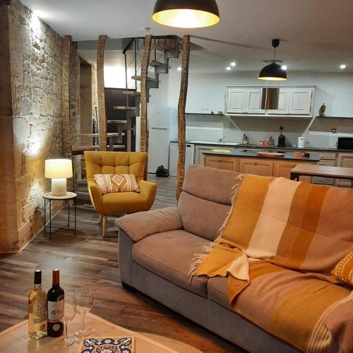 un salon avec un canapé et une cuisine dans l'établissement Le Clos Fénelon, à Sarlat-la-Canéda