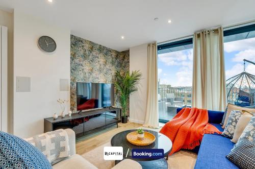 a living room with a blue couch and a tv at Last-Minute Grabs l Cozy Apt in Camden Town By Capital Retreats Short Lets & Serviced Accommodation London With Balcony, Free WiFi in London