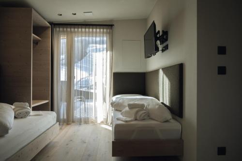 a bedroom with two beds and a large window at Haunold Homes in San Candido