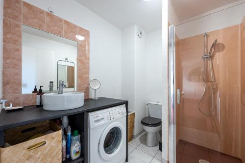 ein Badezimmer mit Waschbecken und Waschmaschine in der Unterkunft Le Ptit Bois - Piscine partagée in Saint-Laurent-en-Grandvaux