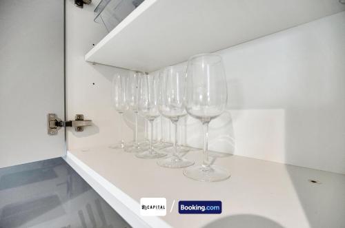 a row of wine glasses sitting on a shelf at Last-Minute Grabs l Cozy Apt in Camden Town By Capital Retreats Short Lets & Serviced Accommodation London With Balcony, Free WiFi in London