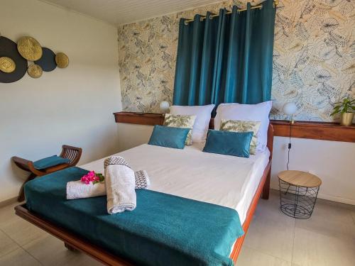 ein Schlafzimmer mit einem Bett mit einem blauen Vorhang in der Unterkunft Kay Lucile, Vue mer sur les hauteurs du Carbet, 5 minutes plage in Le Carbet