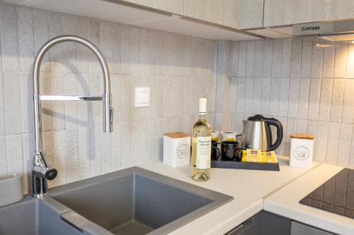 a kitchen counter with a sink and a bottle of wine at Smart Home Corfu Maisonette in Alykes Potamou