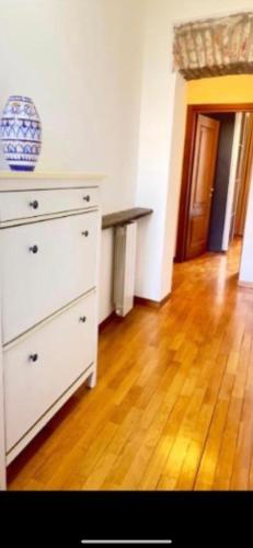 a white dresser in a room with a wooden floor at Apartment suite in Brera in Milan