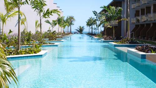 an infinity pool at a resort with palm trees at Crowne Plaza Fiji Nadi Bay Resort & Spa by IHG in Nadi